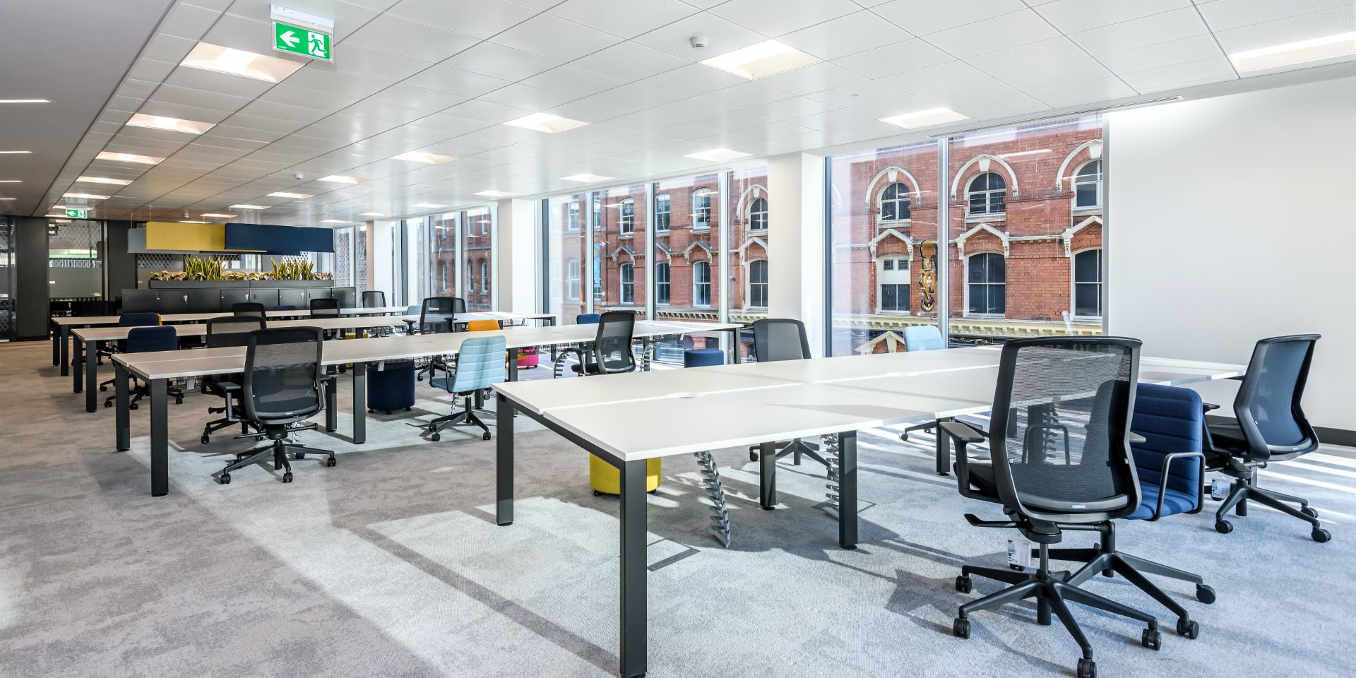 Rows of desks and a glass fronted board room.